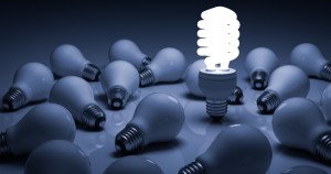 Lit energy saving lightbulb amongst unlit incandescent bulbs